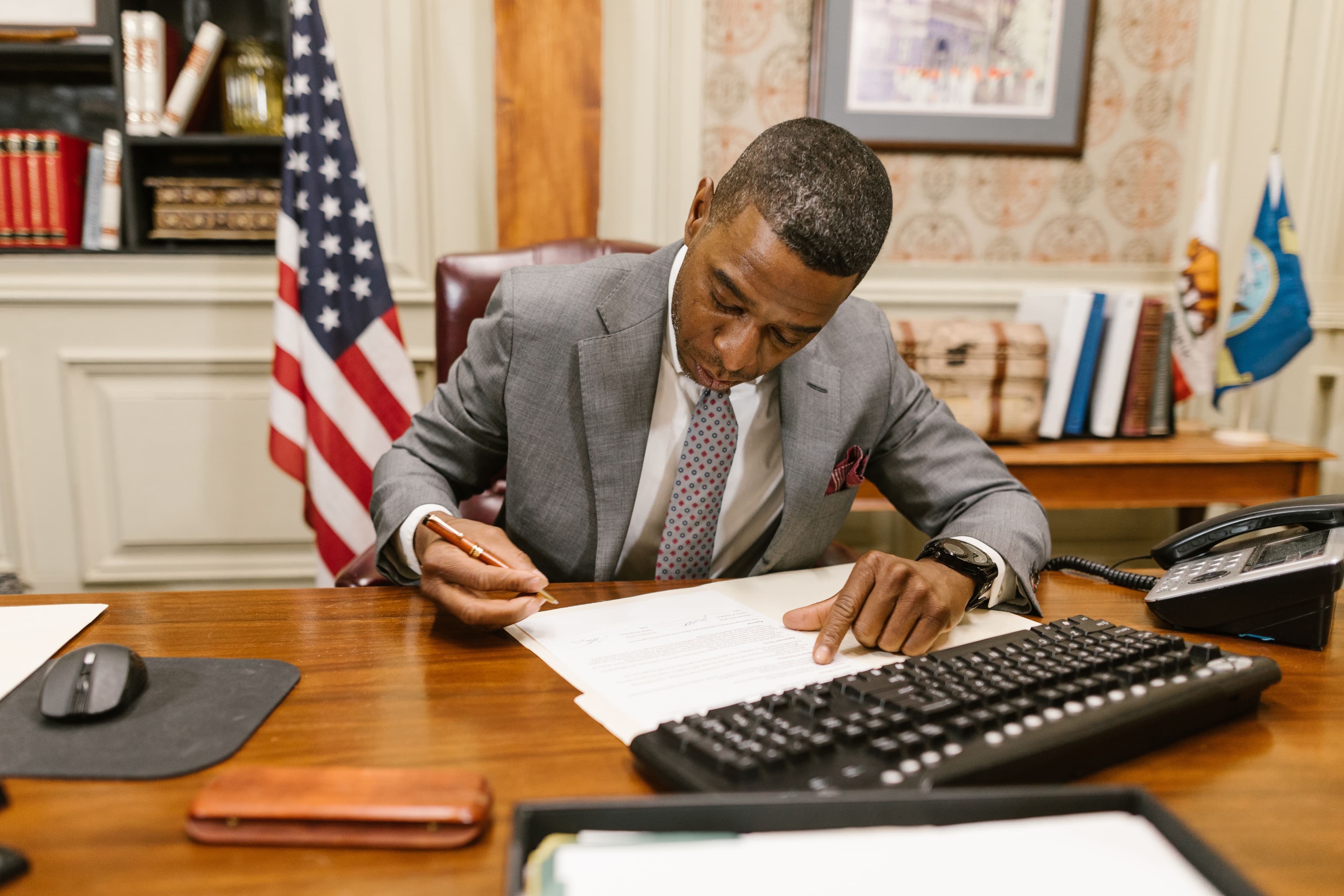 Attorney reviewing and signing estate documents at a desk